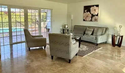 a living room with a couch and a table and chairs at House across from Baptist Hospital in Sunset Corners