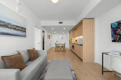 a living room with a couch and a kitchen at Modern Downtown Miami Condo w Pool and Gym in Miami