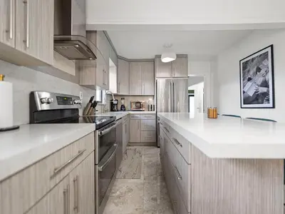 a large kitchen with white counter tops and wooden cabinets at The Gilded Palm - Near Design District - Pool & Hot Tub in Miami