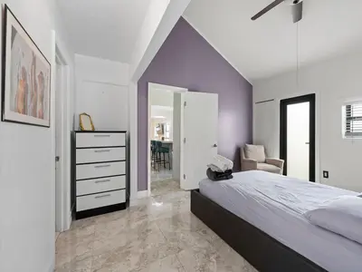 a bedroom with a bed and a dresser with a mirror at The Gilded Palm - Near Design District - Pool & Hot Tub in Miami