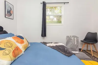 a bedroom with a bed and a chair and a window at Serene Cottage Retreat Ideal for Couples & Solo Travelers in Miami