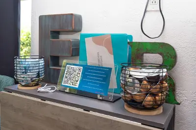 a table with a laptop and two vases on it at Serene Cottage Retreat Ideal for Couples & Solo Travelers in Miami