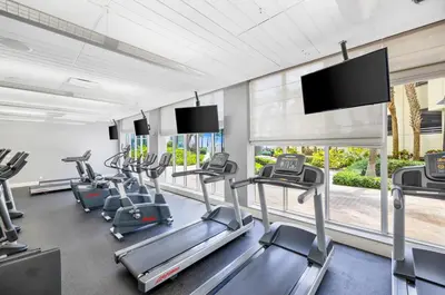 a gym with cardio machines and a flat screen tv at C16P Oceanfront Penthouse in Hollywood FL in Hollywood