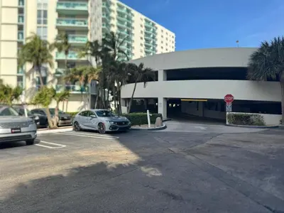a parking lot with cars parked in front of a building at C16P Oceanfront Penthouse in Hollywood FL in Hollywood