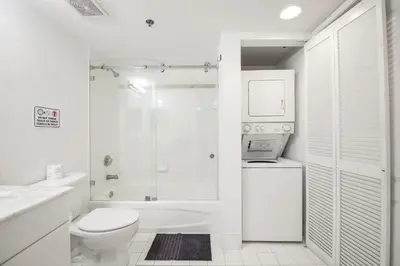 a white bathroom with a toilet and a shower at Brickell Stay with City Views in Miami