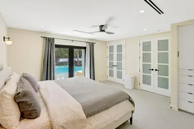 a bedroom with a large bed and a pool at Hollywood Palms: Mins to beach, Pool, Spa, BBQ in Hollywood