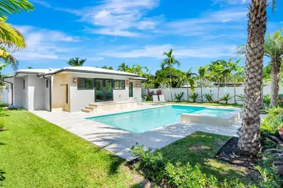 a house with a swimming pool in a yard at Hollywood Palms: Mins to beach, Pool, Spa, BBQ in Hollywood