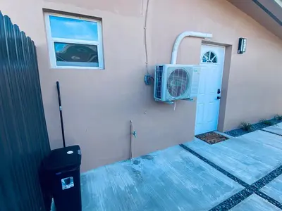 a building with a fan and a window and a door at The Luxe Studio in Miami Gardens