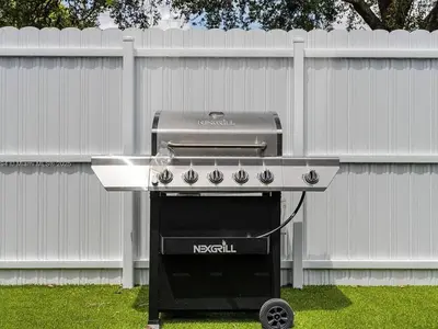 a grill sitting in a yard next to a fence at Large 4 bedroom Midtown Great Area in Miami