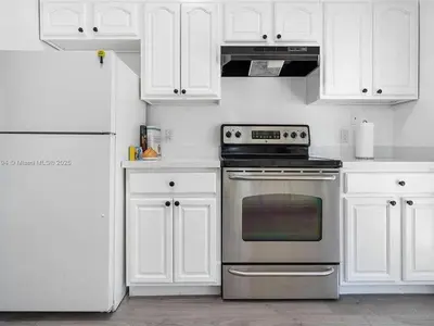 a white kitchen with a stove and white cabinets at Large 4 bedroom Midtown Great Area in Miami