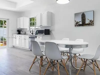 a kitchen with white cabinets and a table and chairs at Large 4 bedroom Midtown Great Area in Miami