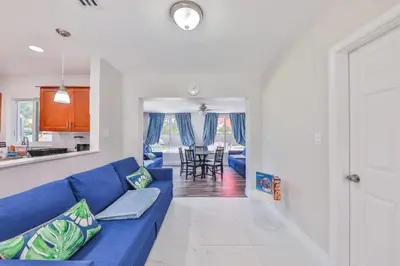 a living room with a blue couch and a kitchen at Chill Zona Arizona Villa Perfect Cruise Stay in Fort Lauderdale