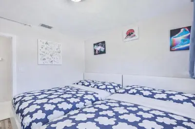 a bedroom with two beds and pictures on the wall at Chill Zona Arizona Villa Perfect Cruise Stay in Fort Lauderdale