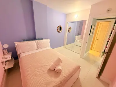 a small bedroom with a bed and a mirror at Modern 2BR beachfront with pool & tennis view in Sunny Isles Beach