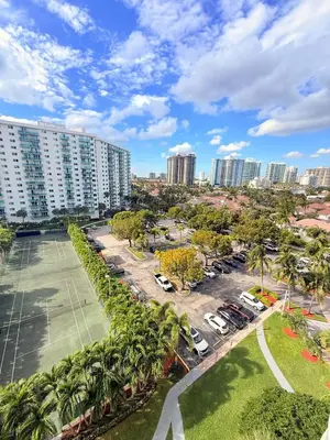 an aerial view of a parking lot with palm trees and buildings at Modern 2BR beachfront with pool & tennis view in Sunny Isles Beach
