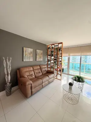 a living room with a brown couch and a table at Modern 2BR beachfront with pool & tennis view in Sunny Isles Beach