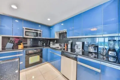 a large blue kitchen with blue cabinets and appliances at Introdused by Ocean Reserve free parking STR-02559 in Sunny Isles Beach