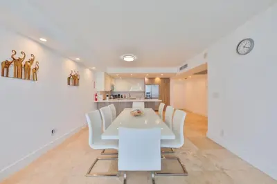 a dining room with a white table and white chairs at 2bed free parking ocean view STR - 02584 in Sunny Isles Beach