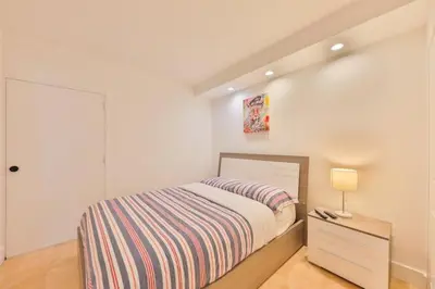 a bedroom with a bed and a dresser with a lamp at 2bed free parking ocean view STR - 02584 in Sunny Isles Beach