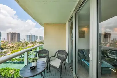 a balcony with a table and chairs and a view of a city at 2bed free parking ocean view STR - 02584 in Sunny Isles Beach