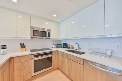 a kitchen with wooden cabinets and stainless steel appliances at 2bed free parking ocean view STR - 02584 in Sunny Isles Beach