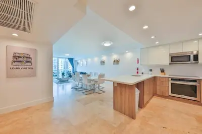 a large kitchen with a table and chairs in it at 2bed free parking ocean view STR - 02584 in Sunny Isles Beach