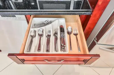 a set of silver utensils sitting on a wooden tray at Ocean view Penthouse - Royal stay in Sunny Isles Beach