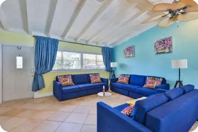 a living room with blue couches and a ceiling fan at LUX View Villa in Fort Lauderdale
