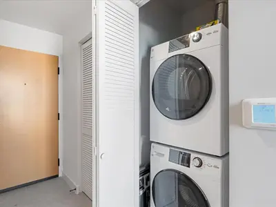 a washing machine and a dryer in a laundry room at Condo Steps from Bayfront & the Kaseya Center in Miami