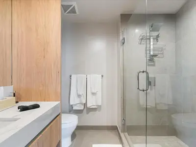 a bathroom with a toilet and a glass shower at Condo Steps from Bayfront & the Kaseya Center in Miami