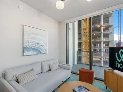 a living room with a couch and a large window at Condo Steps from Bayfront & the Kaseya Center in Miami