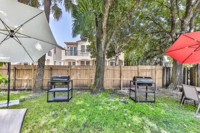 a yard with two tables and two chairs with umbrellas at Fort Lauderdale Family Bestseller in Fort Lauderdale