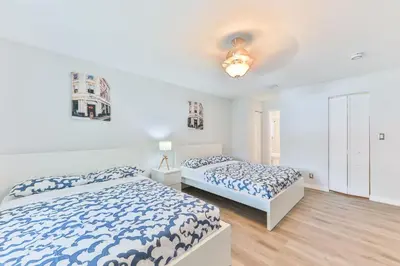 two beds in a bedroom with white walls and wood floors at Fort Lauderdale Family Bestseller in Fort Lauderdale