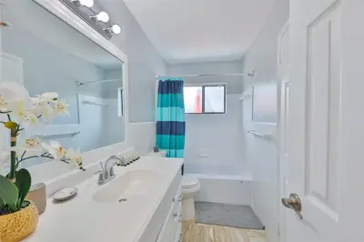 a bathroom with a sink and a toilet and a mirror at Hard Rock Family House in Fort Lauderdale