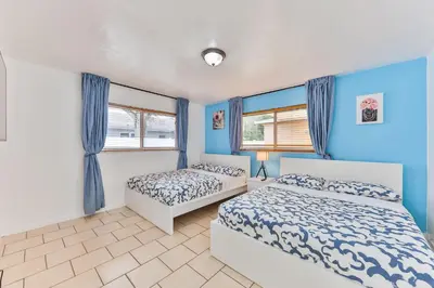 two beds in a bedroom with blue walls and windows at Lucky Family Charm STR-2750 in Hollywood
