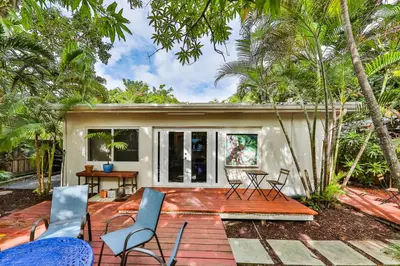 a house with a deck with chairs and trees at Garden botanical Villa with jacuzzi in Hollywood