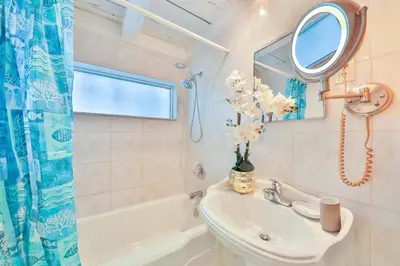 a bathroom with a sink and a mirror and a tub at Garden botanical Villa with jacuzzi in Hollywood