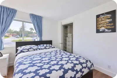a bedroom with a bed with blue curtains and a window at Jungle Happiness Villa STR-2651 in Hollywood