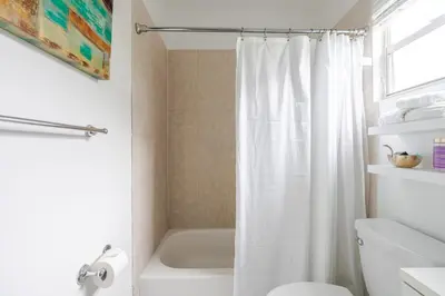 a bathroom with a white shower curtain and a toilet at Sunset Villa- 3 Bedroom 2 Bathroom -6 Beds in Miami