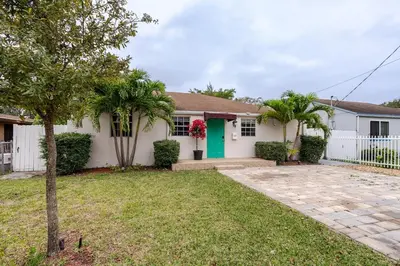 a white house with a green door and palm trees at Sunset Villa- 3 Bedroom 2 Bathroom -6 Beds in Miami