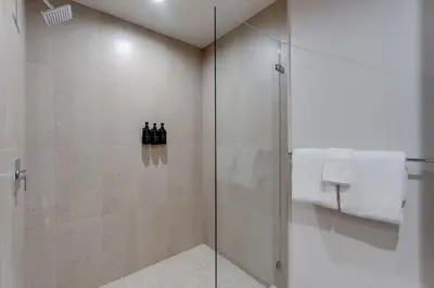 a bathroom with a shower with three bottles of wine at Urban Oasis Luxury Suite- Sky High Amenities in Miami