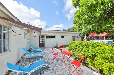 a patio with chairs and tables in front of a house at Family Casa Tranquila de 4 dormitorios in Hollywood