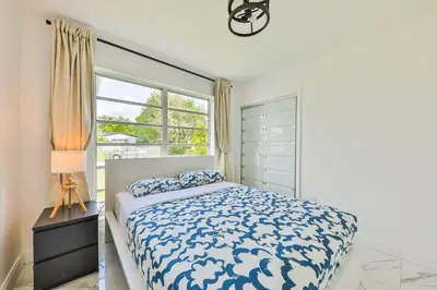 a white bedroom with a bed and a window at Classy Family Stylish Swimming Joy in Hollywood