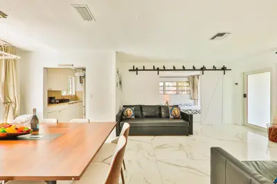 a living room with a table and a couch at Classy Family Stylish Swimming Joy in Hollywood