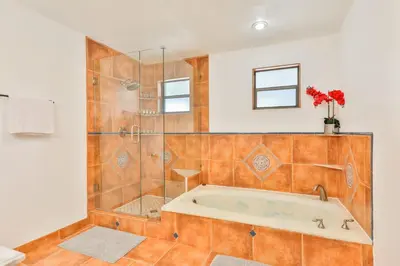 a bathroom with a tub and a glass shower at A star is born villa in Hallandale Beach