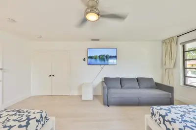 a living room with a couch and a tv on the wall at A star is born villa in Hallandale Beach