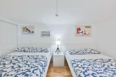 two beds in a room with white walls at Up and down - flat Are boring villa in North Miami Beach