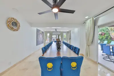 a dining room with a table and blue chairs at Marble Villa Prime Location in Hollywood