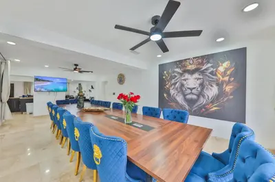 a dining room with a wooden table and blue chairs at Marble Villa Prime Location in Hollywood