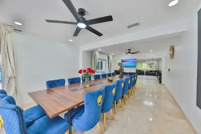 a dining room with a long table and blue chairs at Marble Villa Prime Location in Hollywood